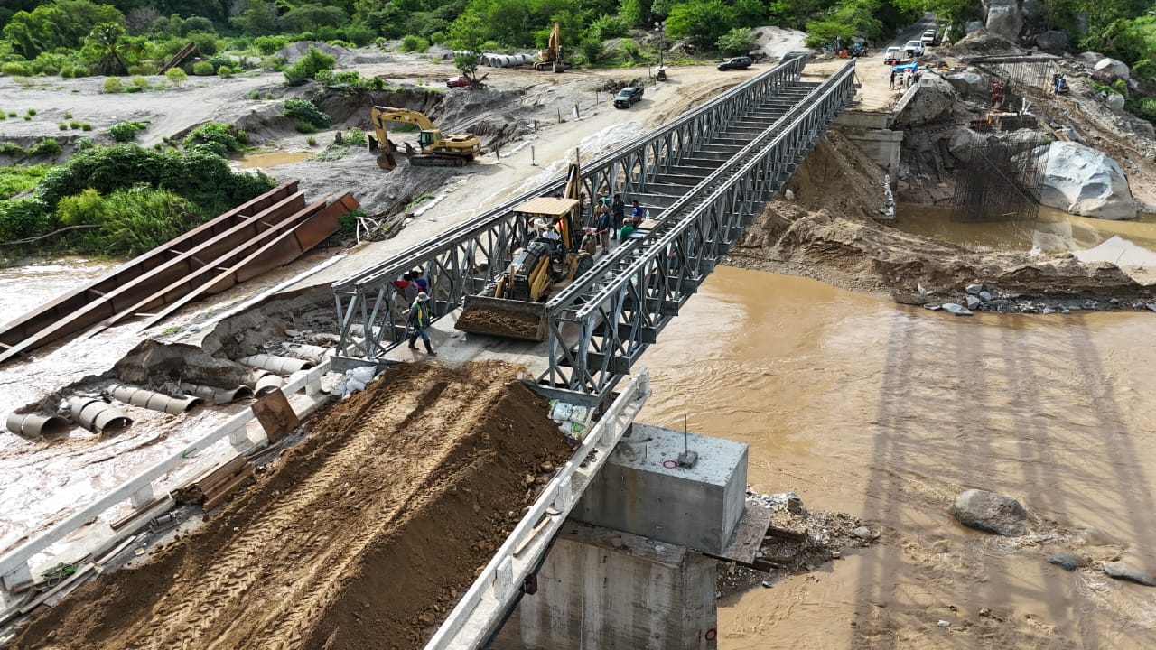 La Secretaría de Infraestructura, Comunicaciones y Transportes, a cargo de Jesús Antonio Esteva Medina, informa que concluyó la instalación del puente provisional metálico tipo Bailey sobre el río Omitlán, con lo que se consiguió restablecer, desde la noche de ayer, la circulación vehicular tras los daños ocasionados por el paso de la Tormenta Tropical “Dalila”. Las afectaciones ocurridas el fin de semana pasado, en el km 5+964 de la carretera Tierra Colorada-Omitlán, provocaron un cierre momentáneo a la circulación, situación que fue resuelta con la operación de la moderna estructura de 90 metros de longitud por 4.20 metros de ancho de calzada y 30 toneladas de capacidad de carga. Cabe señalar que desde hace un par de semanas y ante la inminente temporada de lluvias en la región, la SICT dispuso instalar dicho puente temporal para mantener la conectividad entre municipios de Juan R. Escudero, Tecoanapa, Ayutla de los Libres, San Marcos, Las Vigas y Cruz Grande, beneficiando a una población de 521 mil habitantes de la Costa Chica de Guerrero. Lo anterior, como parte de los trabajos de reconstrucción del Puente Omitlán que tendrá una longitud 220 metros y que resultó afectado por el Huracán “John”, en septiembre de 2024. El puente metálico tipo Bailey, con capacidad para un flujo vehicular de hasta 2 mil vehículos por día, contará para su operación diaria con la presencia de un banderero las 24 horas, encargado de brindar indicaciones a los usuarios para garantizar un tránsito seguro. Cabe destacar que esta moderna estructura para atención de emergencias, propiedad de la SICT, ha sido utilizada anteriormente en otros estados del país y prestada incluso a naciones como Guatemala. Su instalación se realizó en un periodo de 20 días y se empleó un equipo de 35 personas, incluyendo operadores, técnicos, ingenieros y personal auxiliar, así como dos equipos de maquinaria pesada para el armado y lanzado de la estructura. La SICT exhorta a la ciudadanía a respetar los señalamientos instalados y a conducir con extrema precaución al transitar por esta vía.